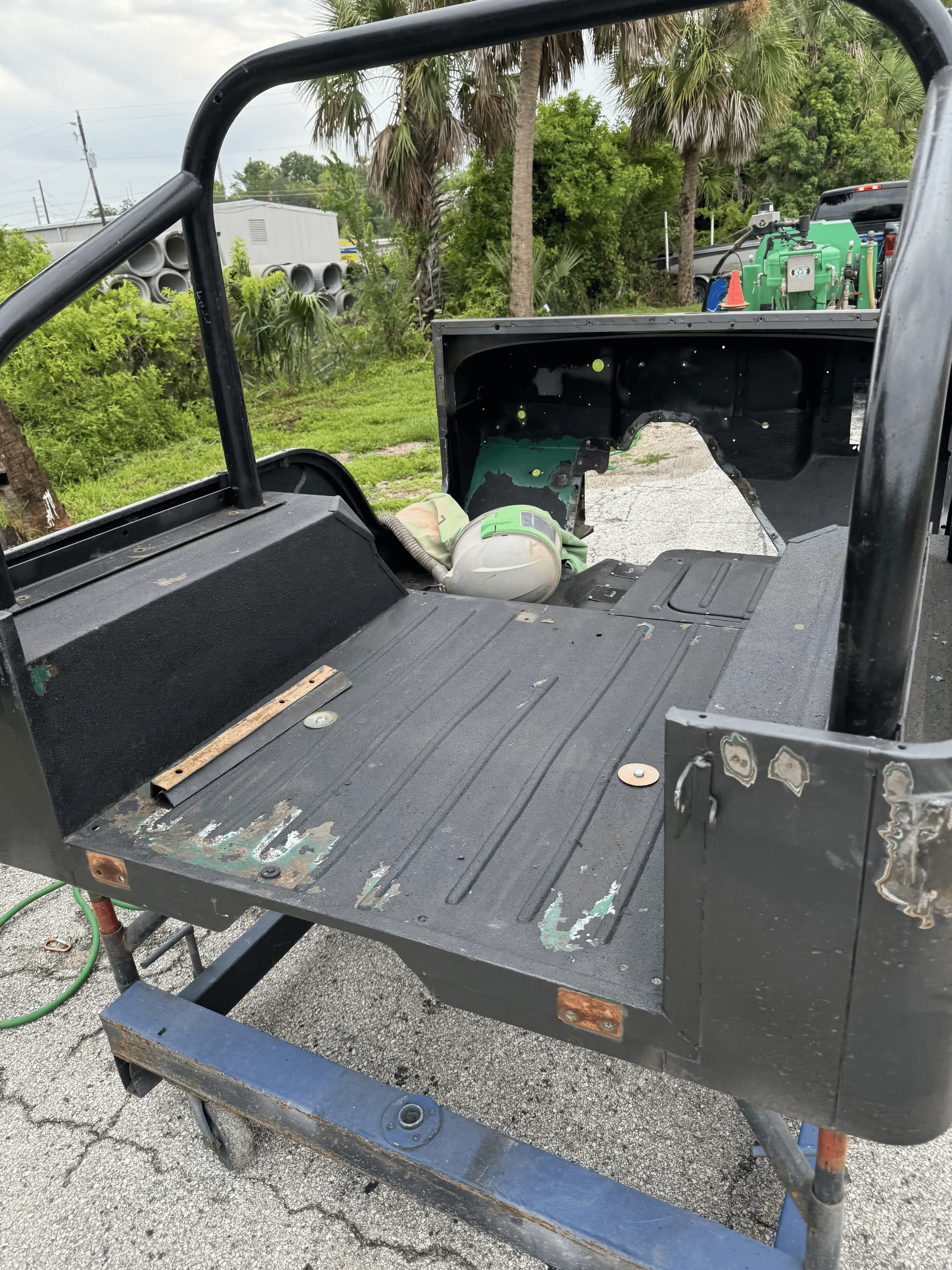Automotive body tub with old paint and rust before sand blasting