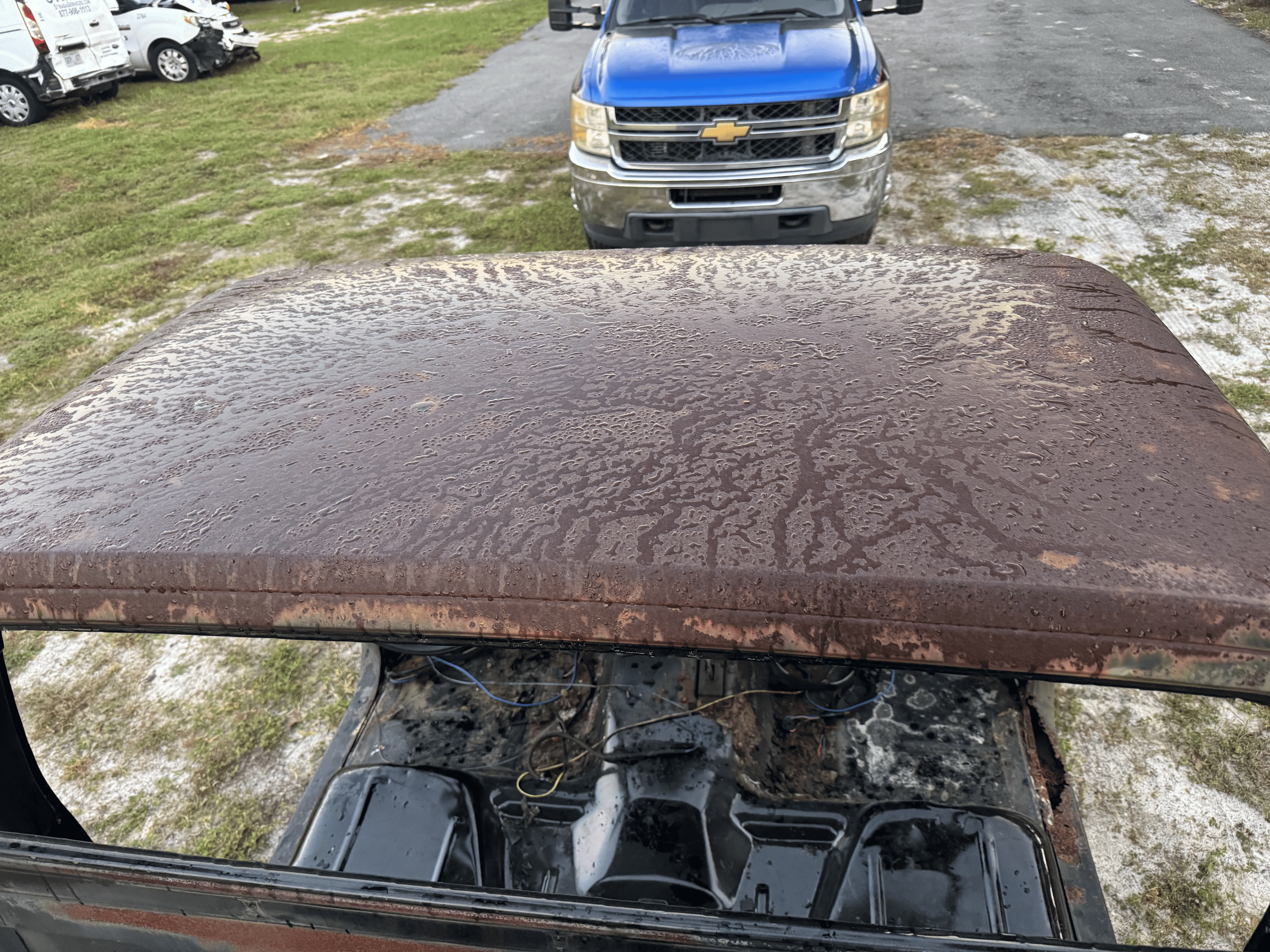 Truck cab roof with aged paint and surface buildup before blasting