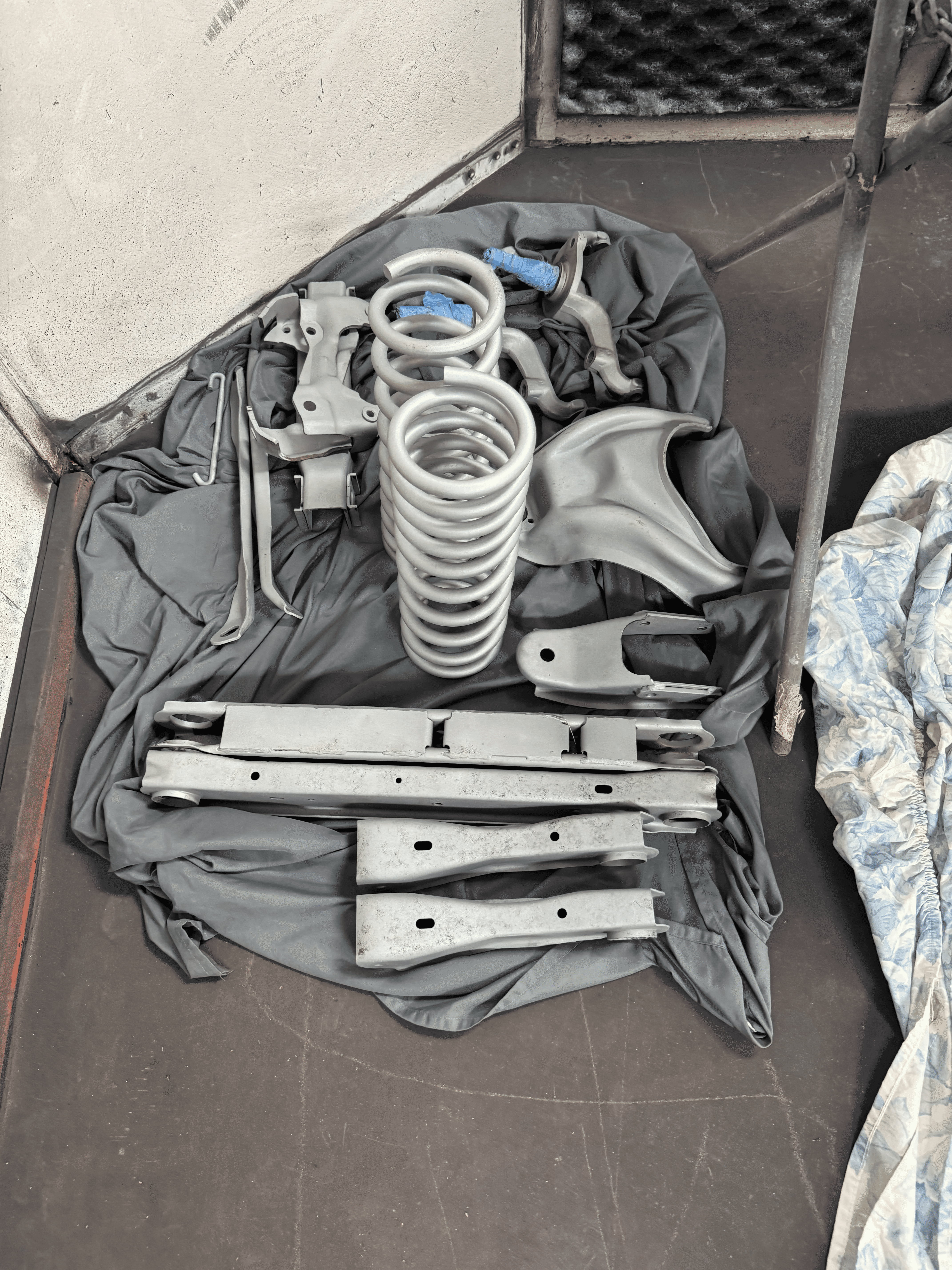 Cleaned automotive frame and suspension components after blasting