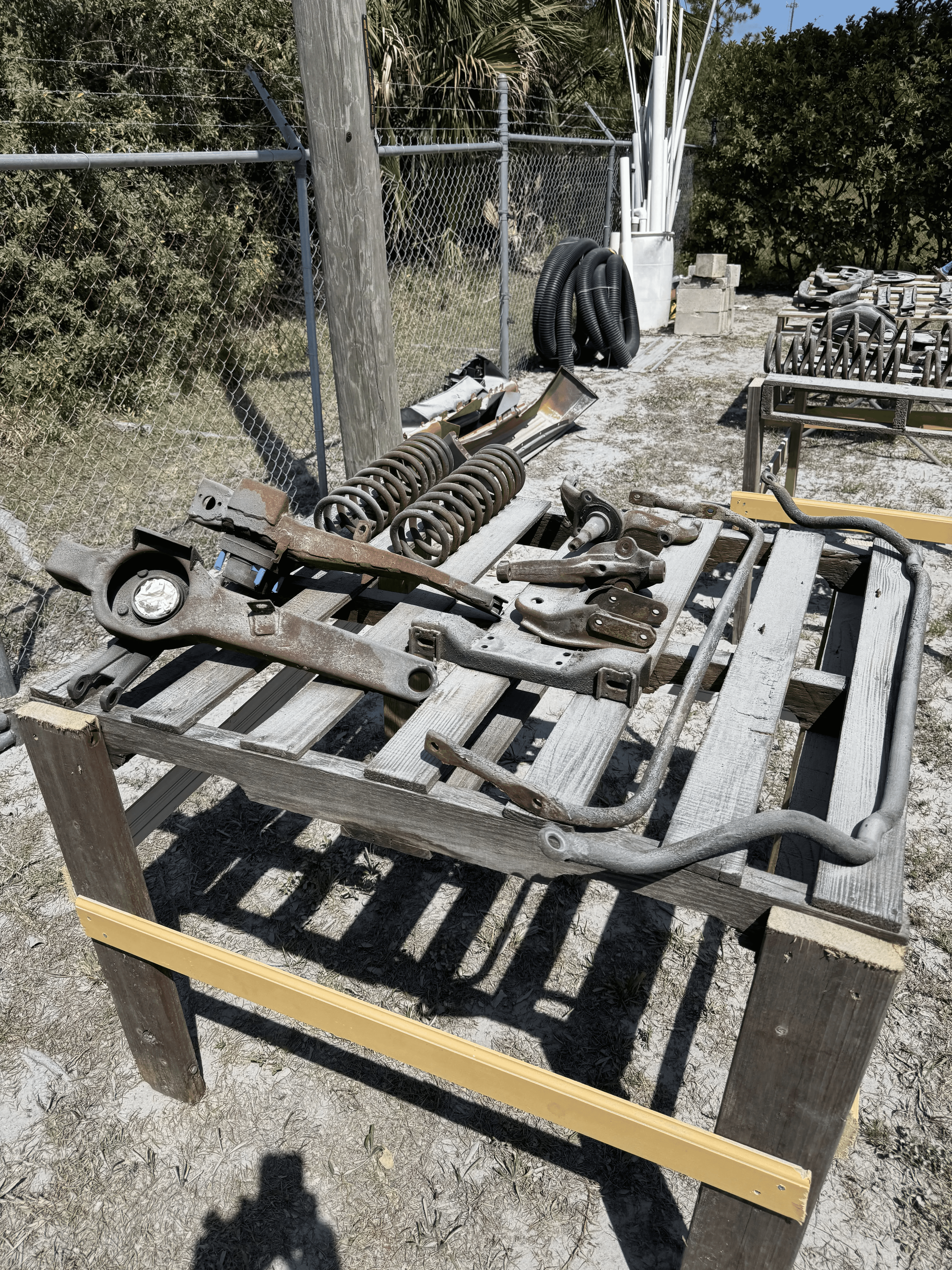Assorted automotive frame and suspension components before blasting